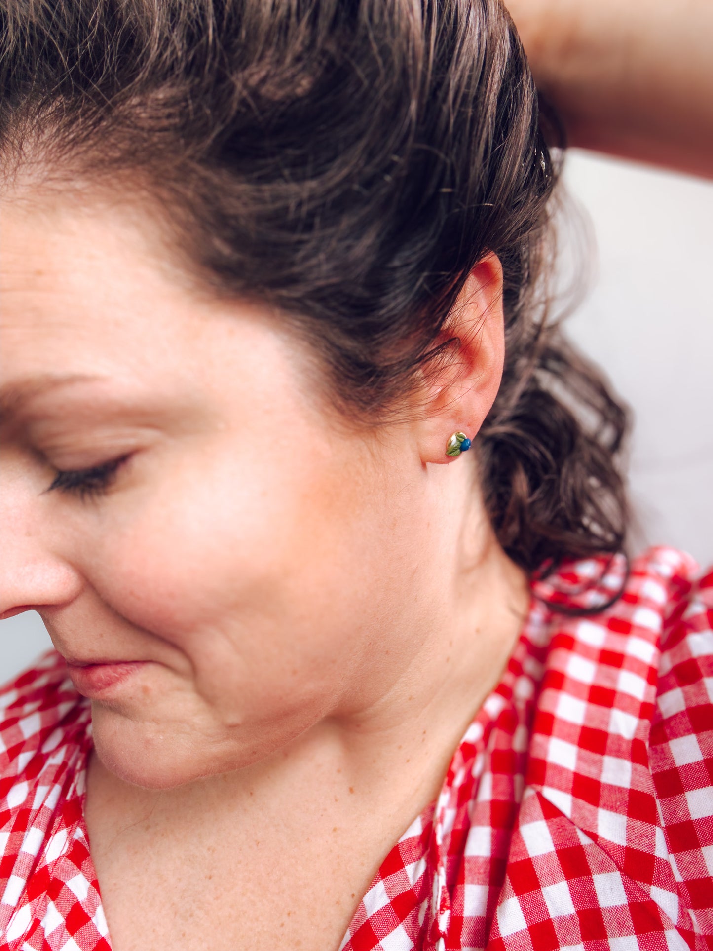 Close-up of a person wearing a red and white checkered shirt with a blurred background
