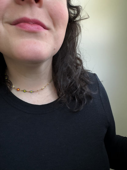 Close-up of a person wearing a black shirt and a necklace with small beads.