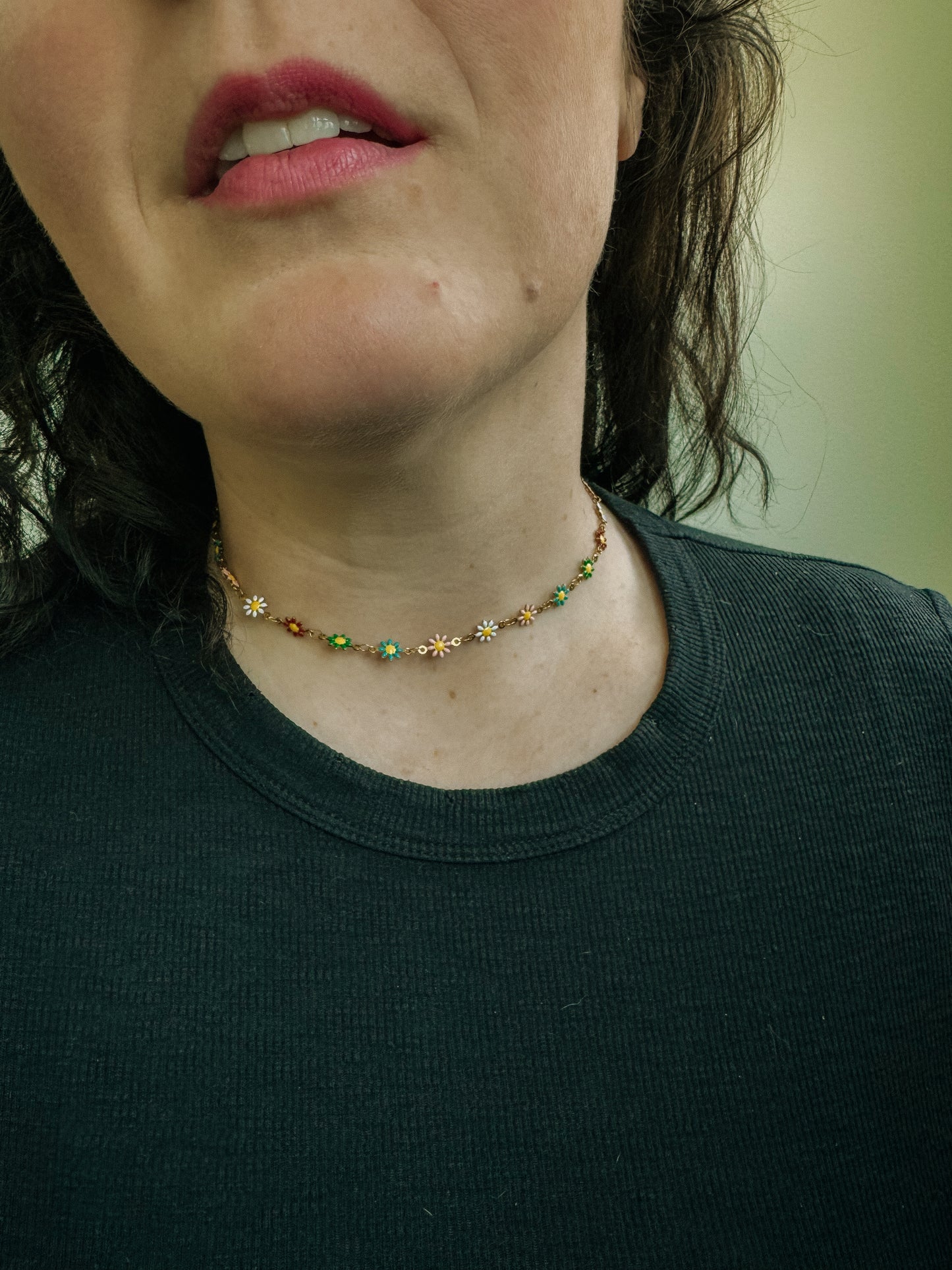 Close-up of a person wearing a necklace with floral designs.