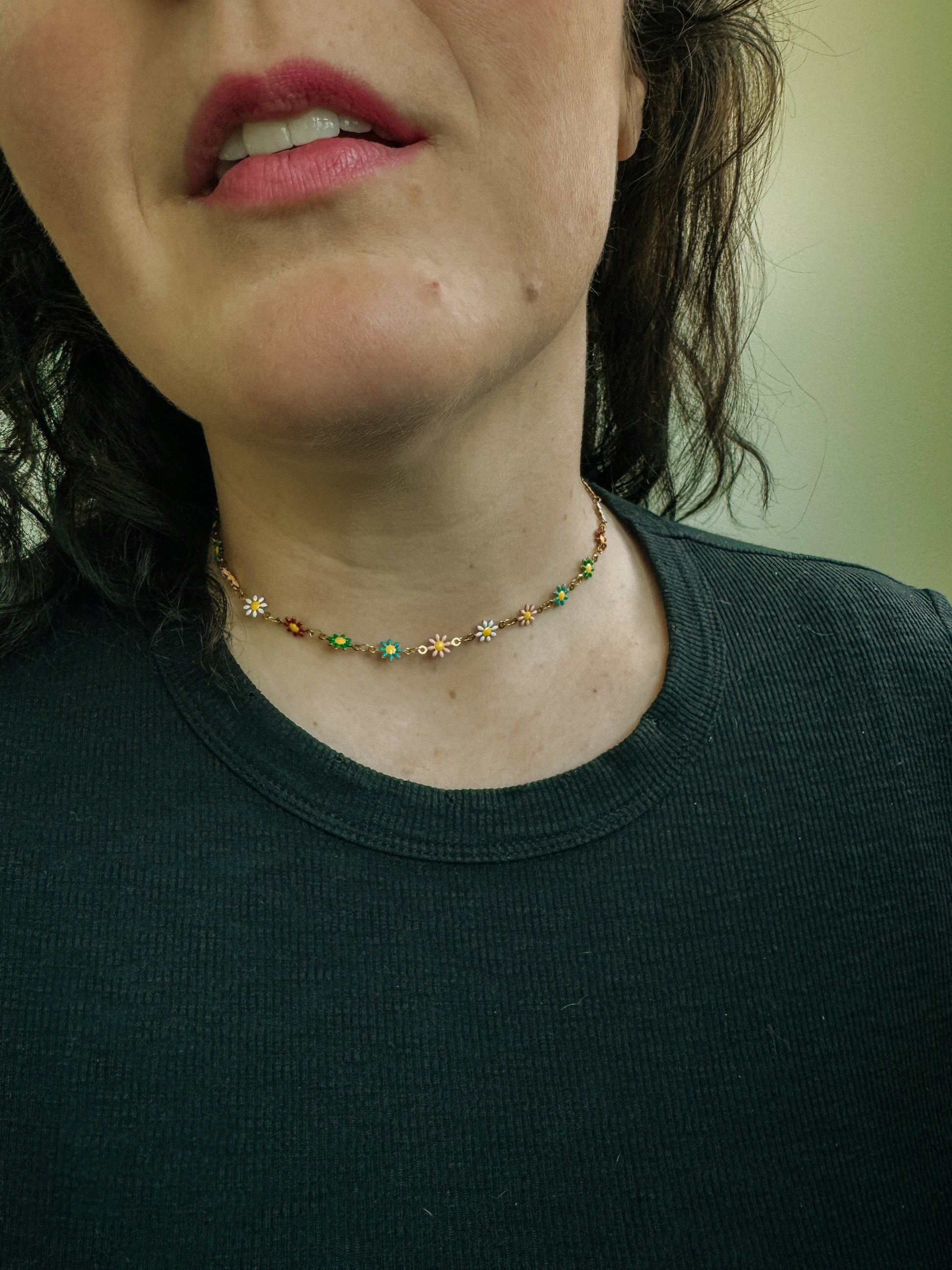 Close-up of a person wearing a necklace with floral designs.