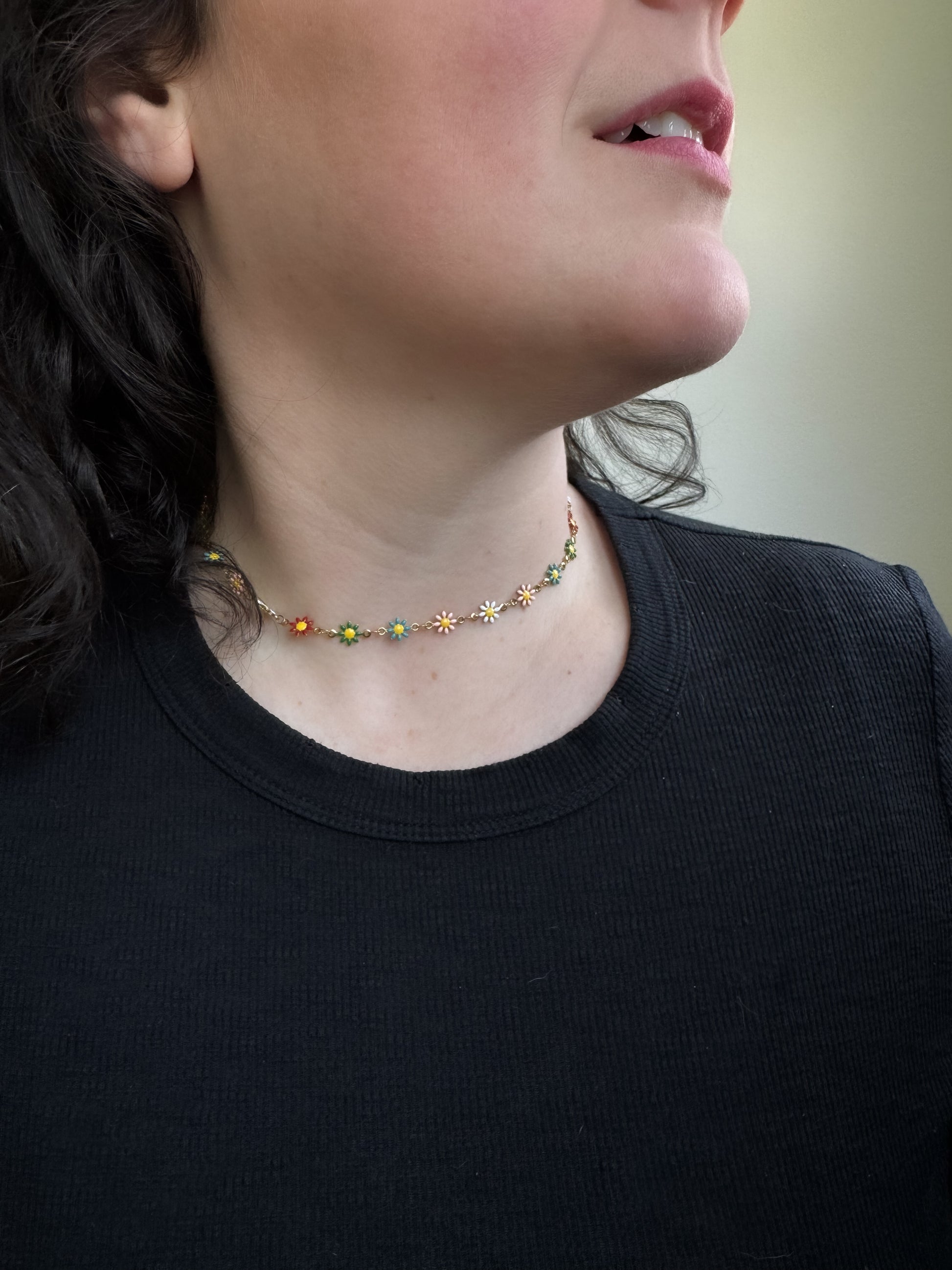 Necklace with colorful beads worn by a person against a neutral background