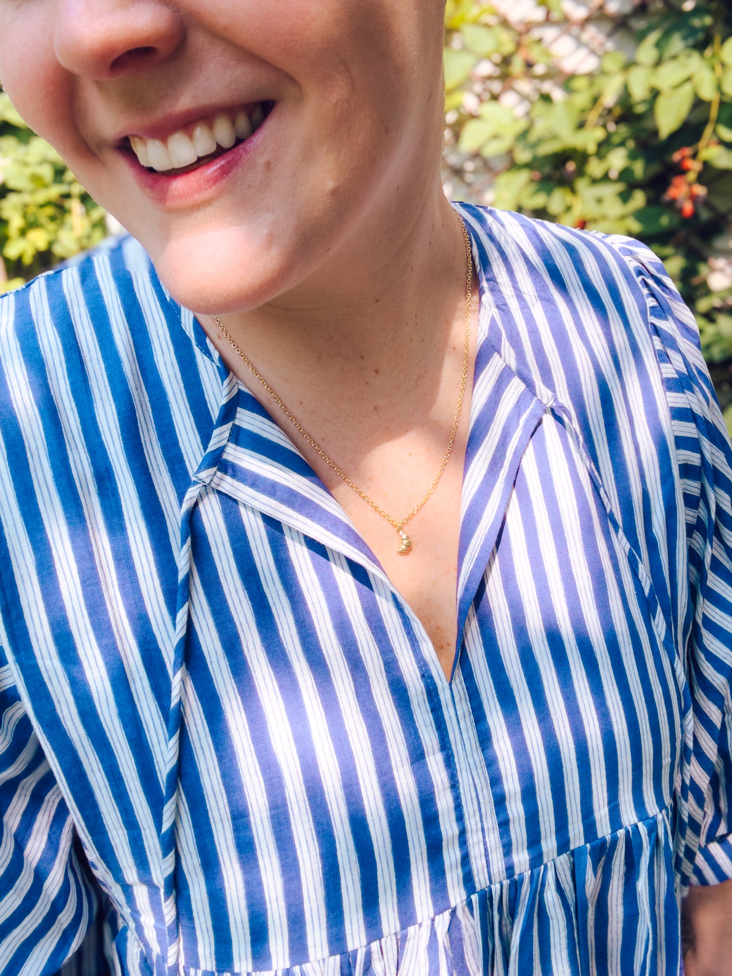 Person wearing a blue and white striped shirt with a blurred background