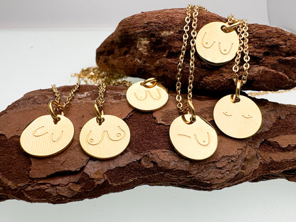 Gold necklaces with round pendants on a wooden surface