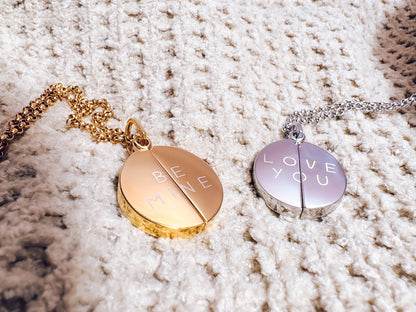 Two necklaces with round pendants on a textured surface