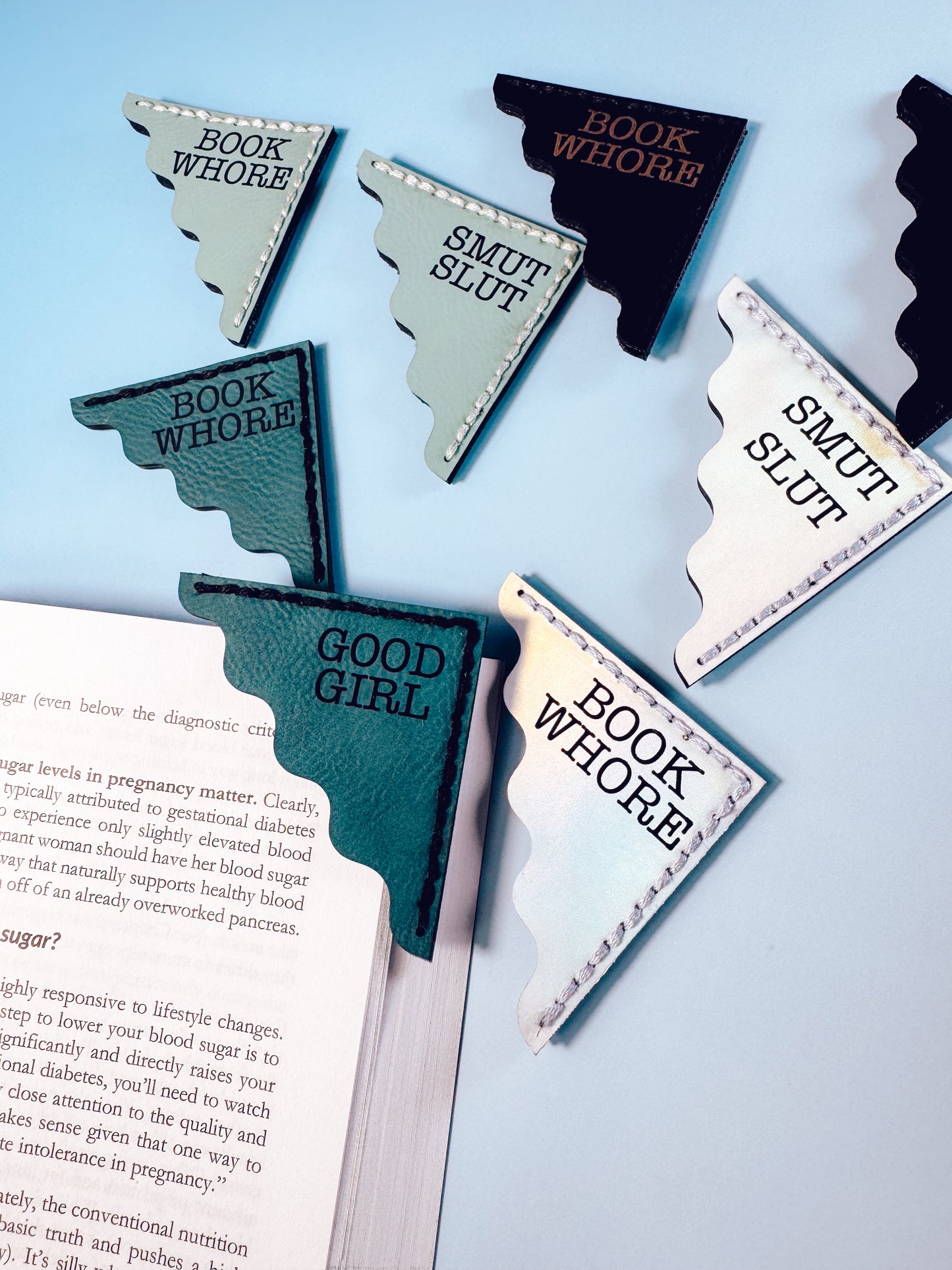 Bookmarks with humorous text on a book against a light blue background