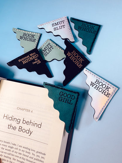 Bookmarks shaped like state outlines with humorous text on a book and blue background