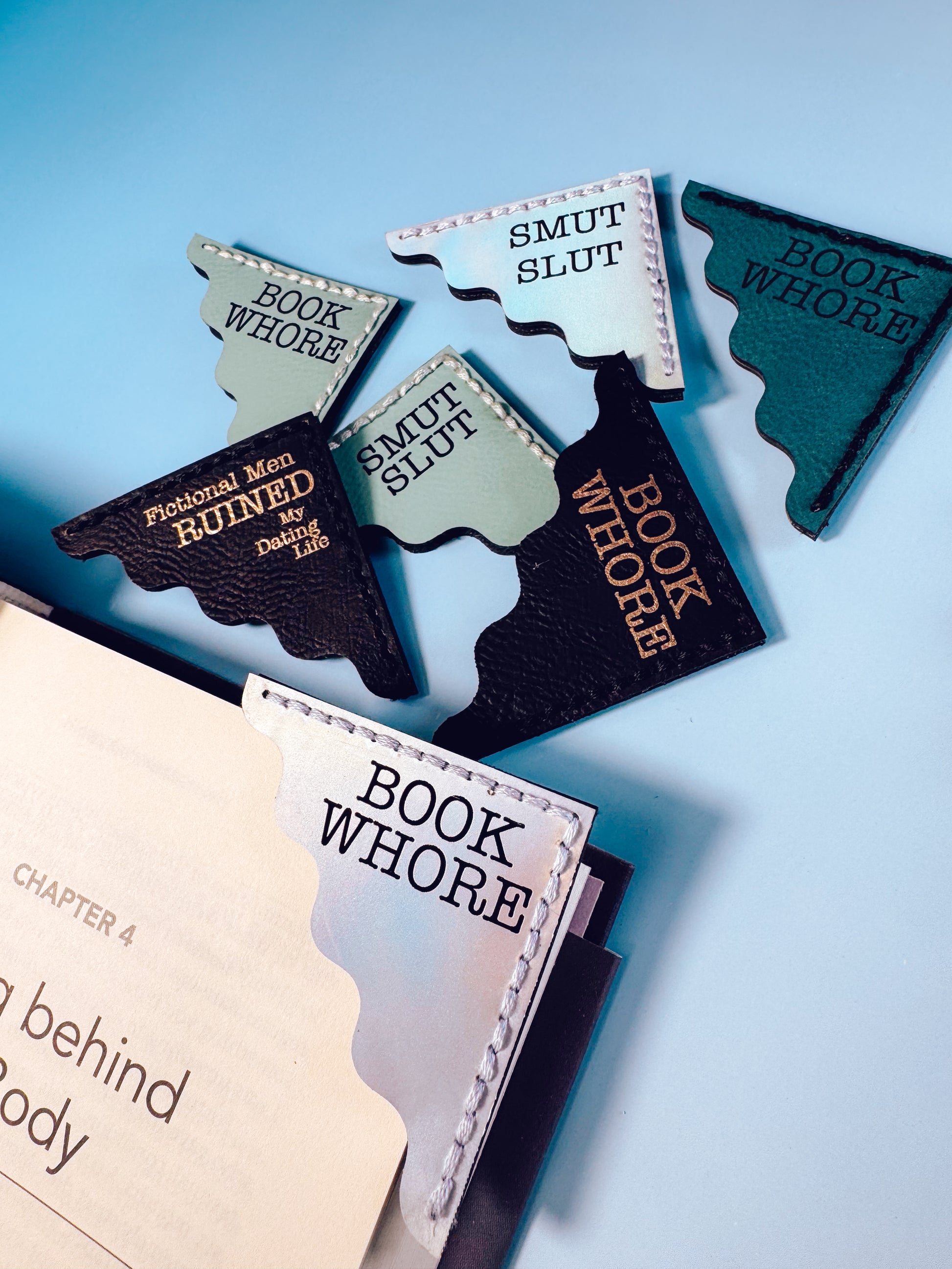 Bookmarks with humorous text on a book against a light blue background